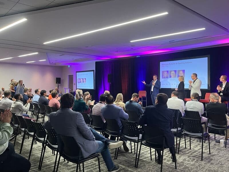 Poppulo leaders welcoming attendees on stage at Pop Summit 2025